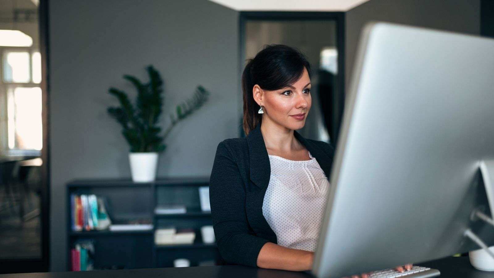 business woman working on a desktop computer in their office